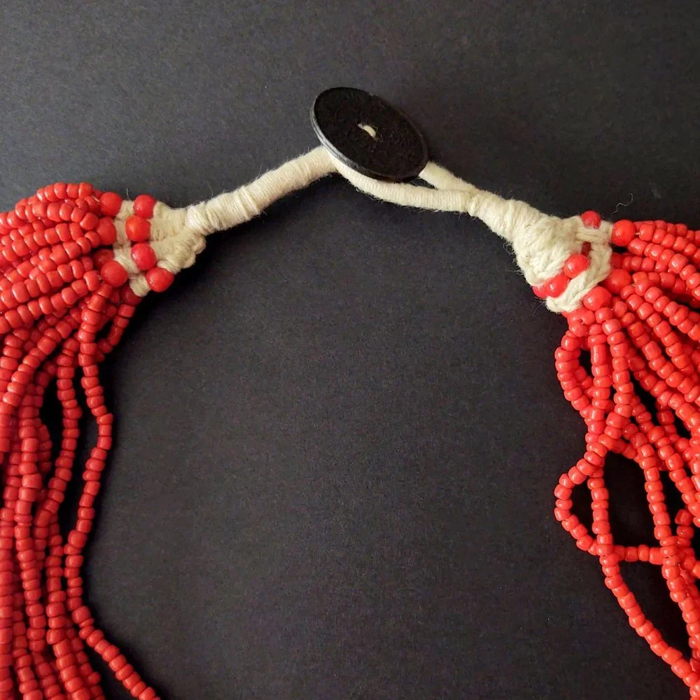 Layered orange beaded necklace with old coin toggle closure
